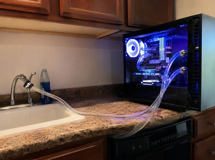 A desktop computer with water cooling hooked up to a kitchen sink, an example of electronics fails.