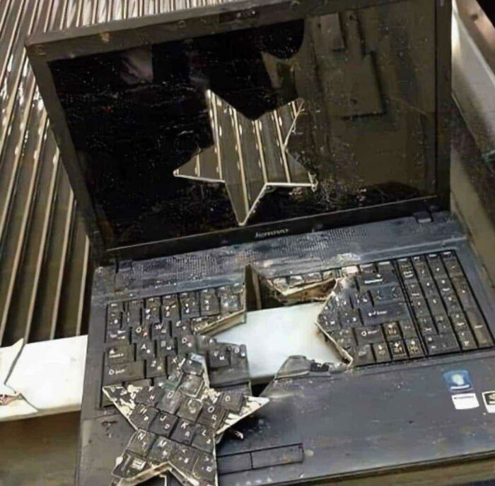 A laptop with a star-shaped hole cut through its screen and keyboard, illustrating electronics fails.