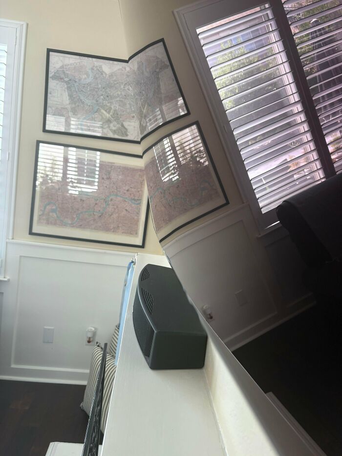 Distorted room with maps on the wall, showcasing an electronics fail where a panoramic photo did not stitch correctly.