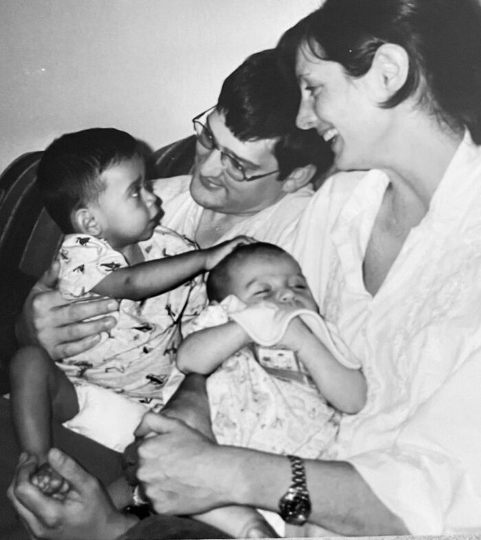 Black and white photo of a family with two adults and two young children, one baby cradled