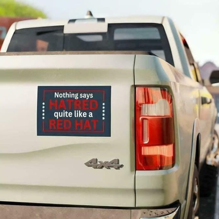 Bumper sticker saying hatred is symbolized by a red hat on a truck