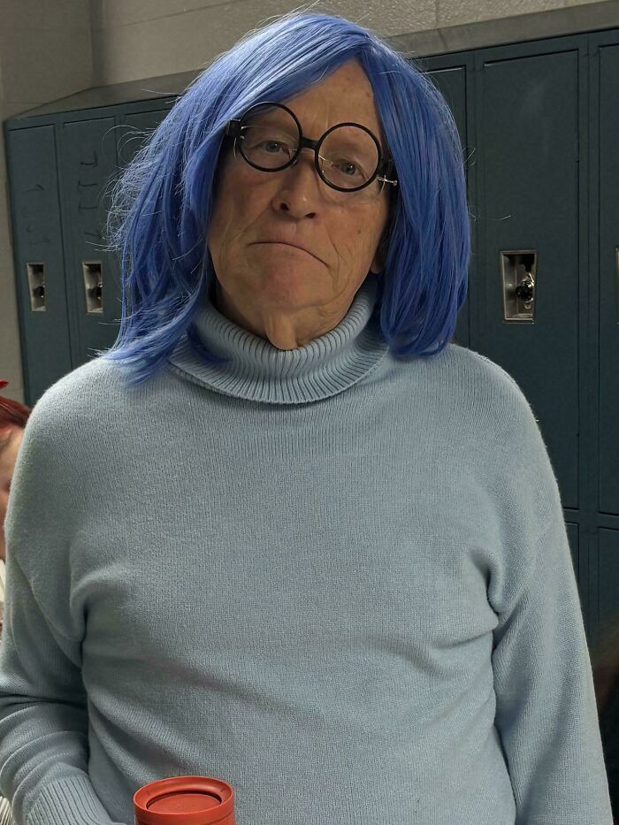 An elderly father in a blue wig and turtleneck, dressed as Sadness from Inside Out, an amazing parent.