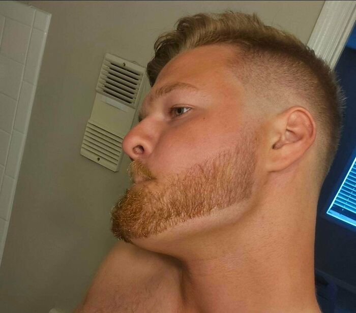 A man with a poorly blended haircut and beard, highlighting a hair salon disaster.