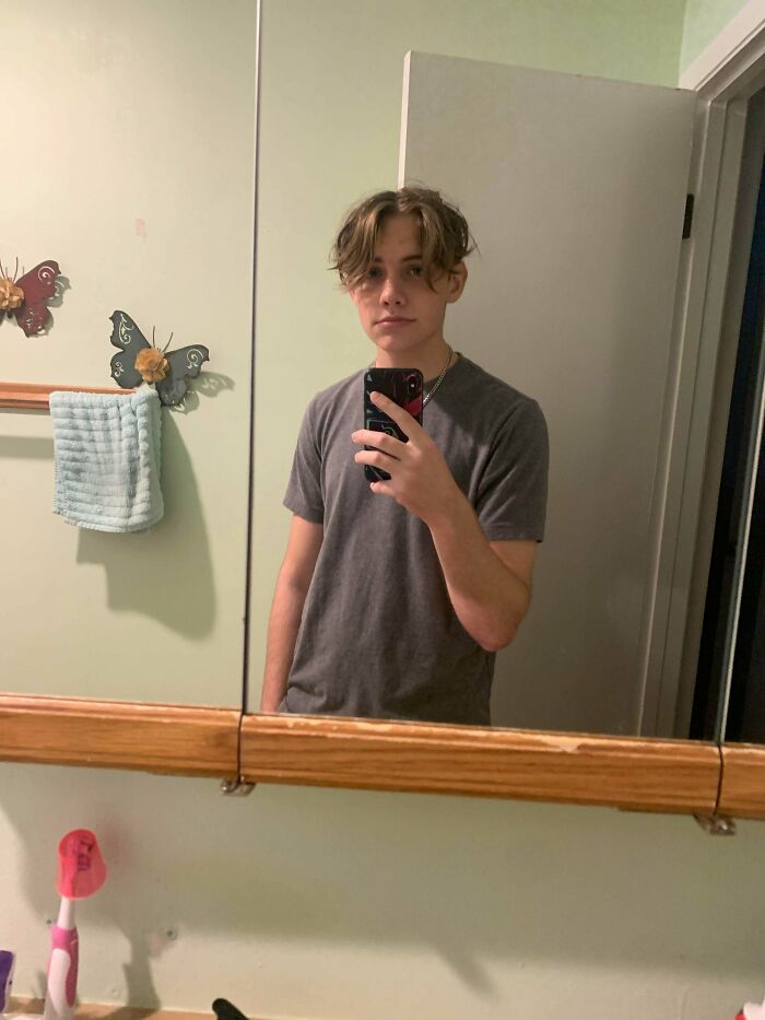 A young man with a hair salon disaster, showcasing a messy, uneven haircut with bangs that are too long and look unstyled.