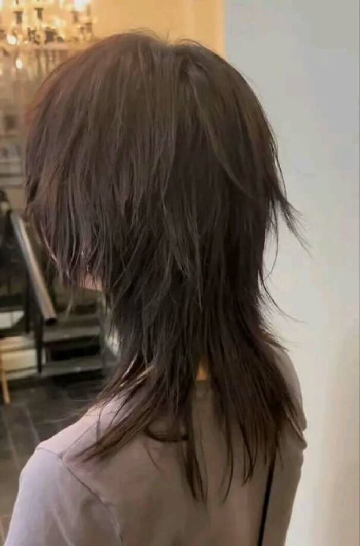 Person with a poorly executed choppy s**g haircut, a hair salon disaster.