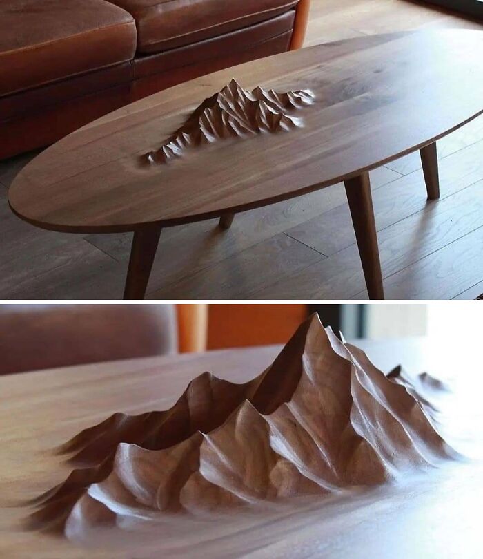 Wooden coffee table with intricate mountain design carved in the surface showcasing creative design