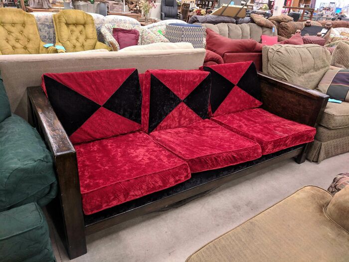 A unique couch with red and black cushions, sure to catch the eye of any interior designer.