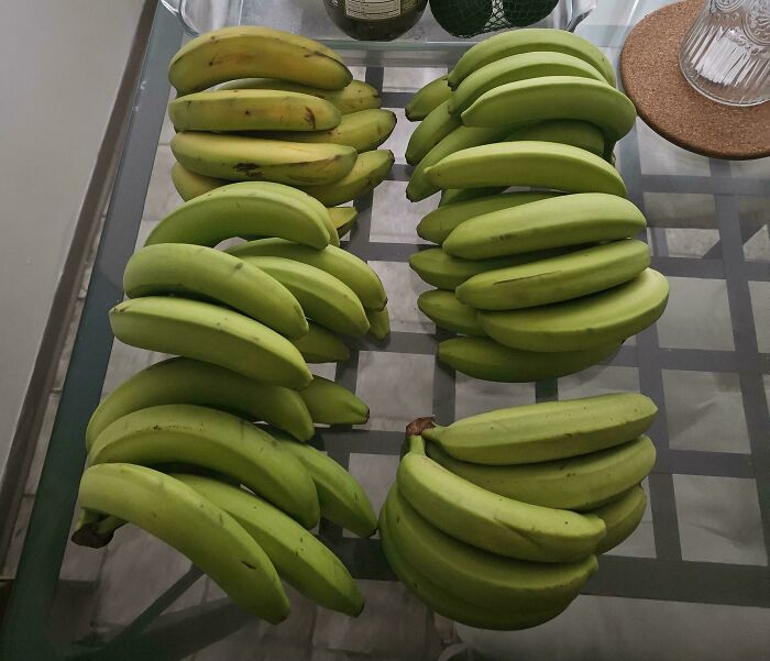 Numerous green and yellow bananas arranged on a glass table, showing a food delivery fail quantity issue.