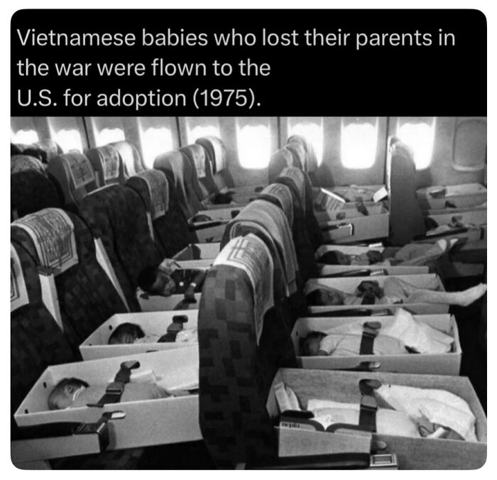 Black and white image of Vietnamese babies in boxes on a plane for adoption during the war, historical context.