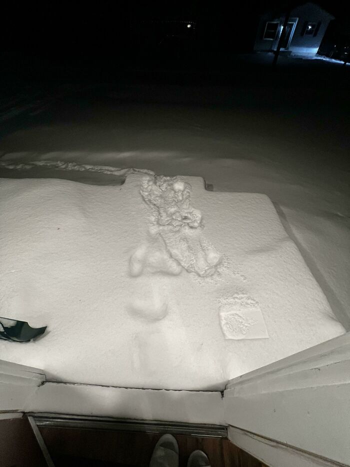 Deep snow covers a doorstep, showing a challenging food delivery scenario.