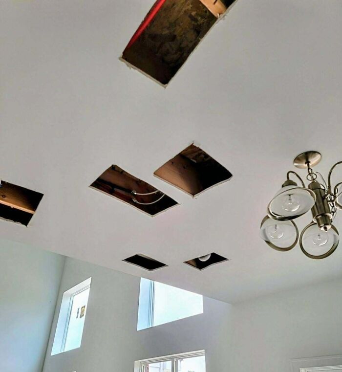A ceiling with several square holes cut out, indicating electronics fails related to IT installation.