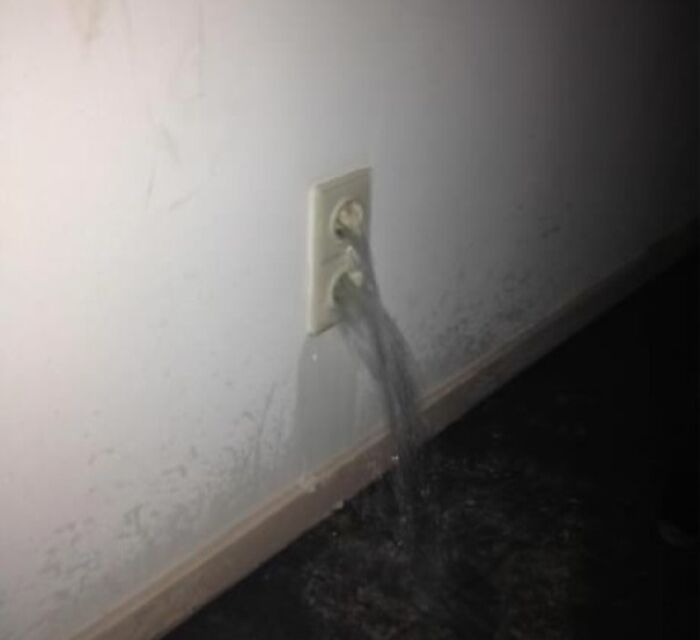 Water pouring out of an electrical outlet, highlighting serious electronics fails and IT issues.