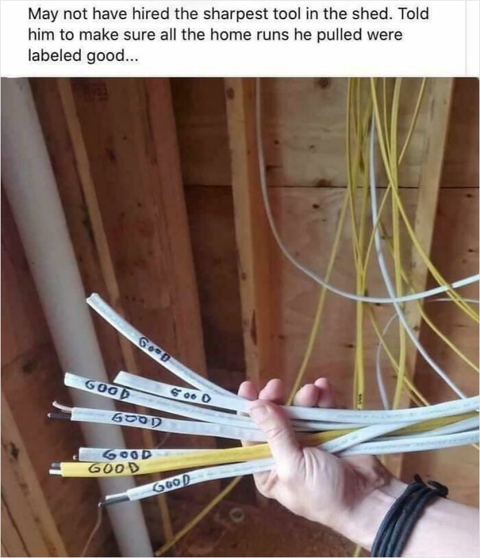 A hand holding electrical wires haphazardly labeled good, showcasing a clear instance of electronics fails and why we respect the IT guy.