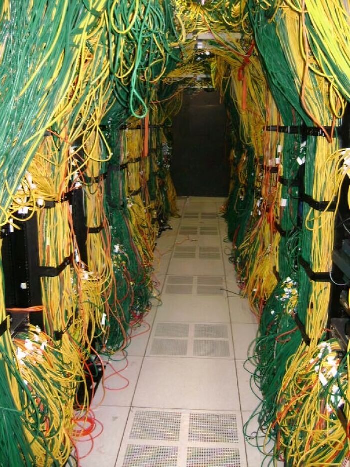 A server room with a chaotic mess of green and yellow cables, illustrating common electronics fails and the importance of IT guy expertise.