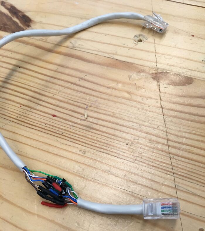 A poorly crimped Ethernet cable with exposed wires, a common electronics fail leading to connectivity issues.