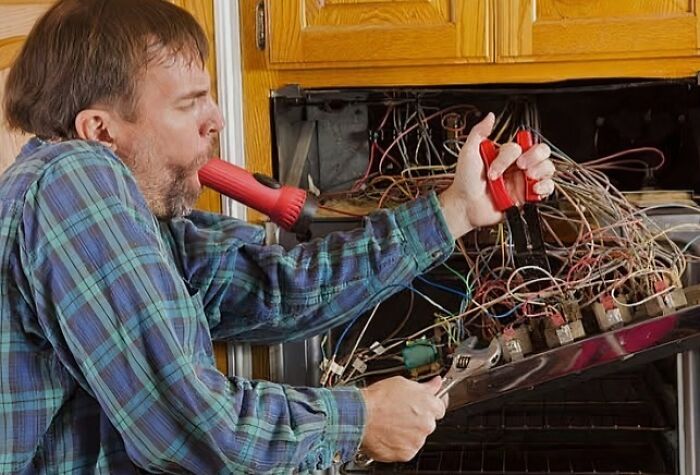 Man attempting to fix electronics fails in a tangled mess of wires, highlighting the importance of IT guy expertise.