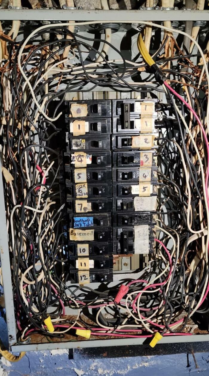 An untidy electrical panel box with multiple electronics fails and messy wiring.
