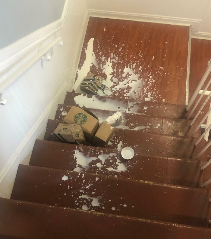 Spilled Starbucks drinks and boxes on a wooden staircase, illustrating a funny or infuriating food delivery fail.