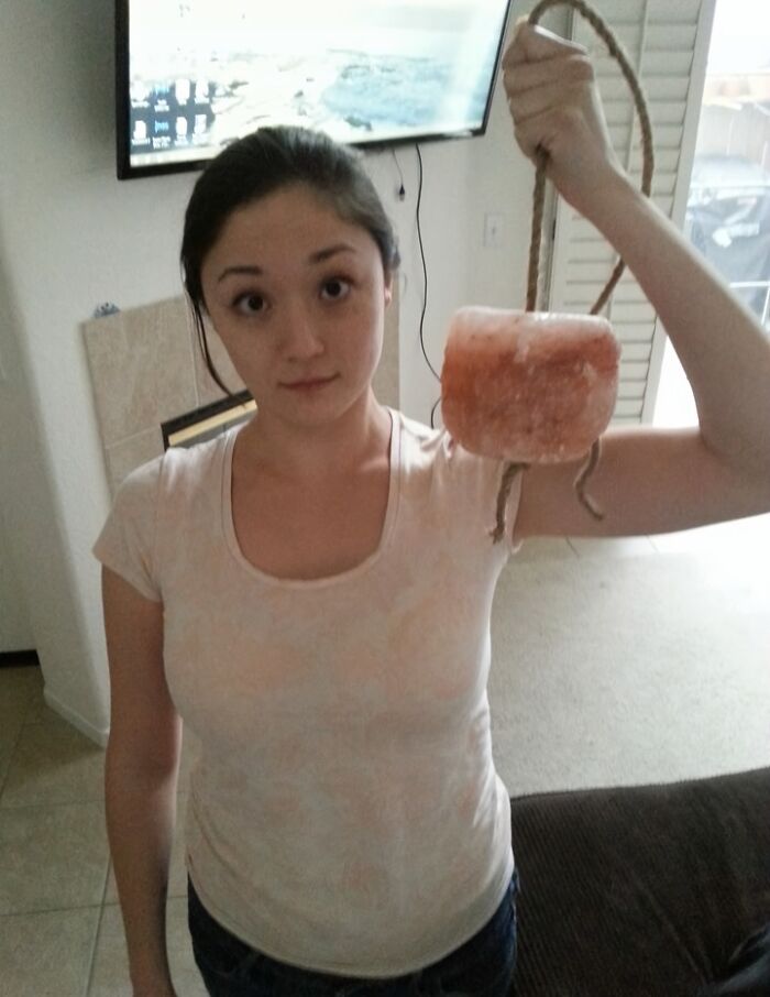 An amazing father gift, a woman holding a large salt lamp on a rope, demonstrating unique parents gifts.