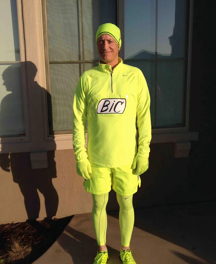 A father dressed in a bright neon yellow running outfit with a BIC logo on his shirt, standing outside for his kids.
