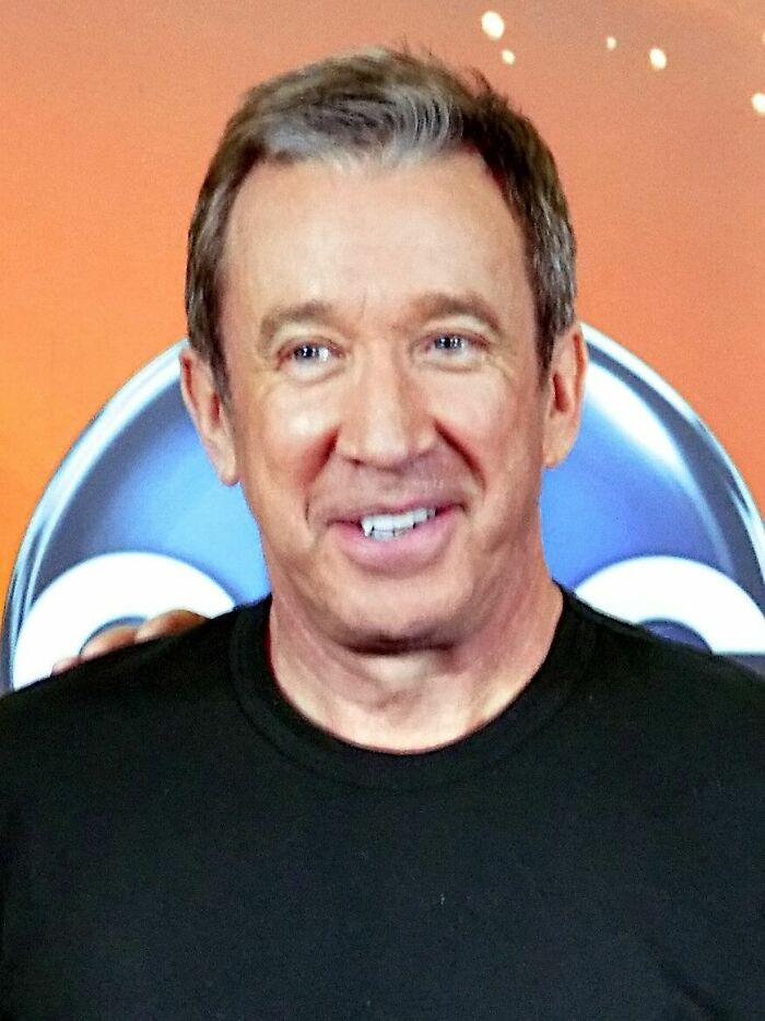 Close-up portrait of Tim Allen smiling in front of a colorful background