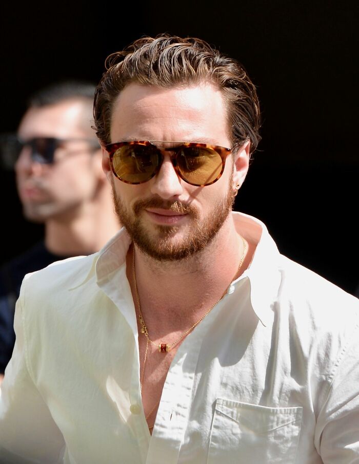 Aaron Taylor-Johnson wearing sunglasses and white shirt in an outdoor setting