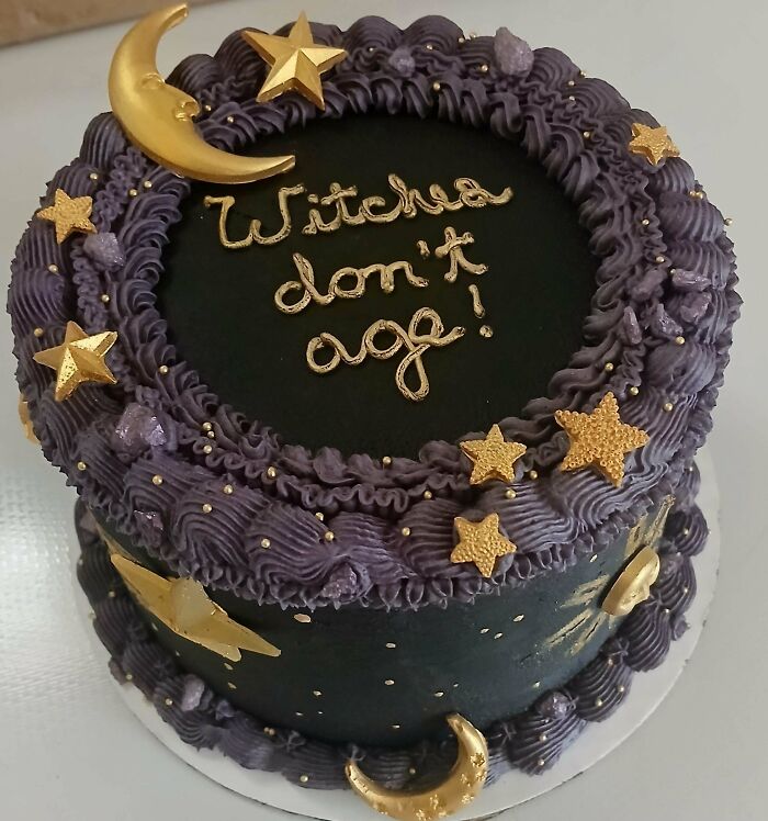 An amazing cake with purple frosting, gold stars, and moons, a treat from talented bakers.