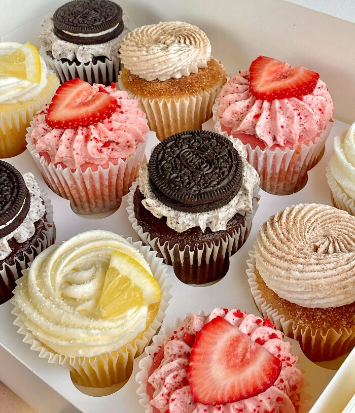 An assortment of cupcakes with various toppings like strawberries, Oreos, and lemon slices, amazing treats by bakers.