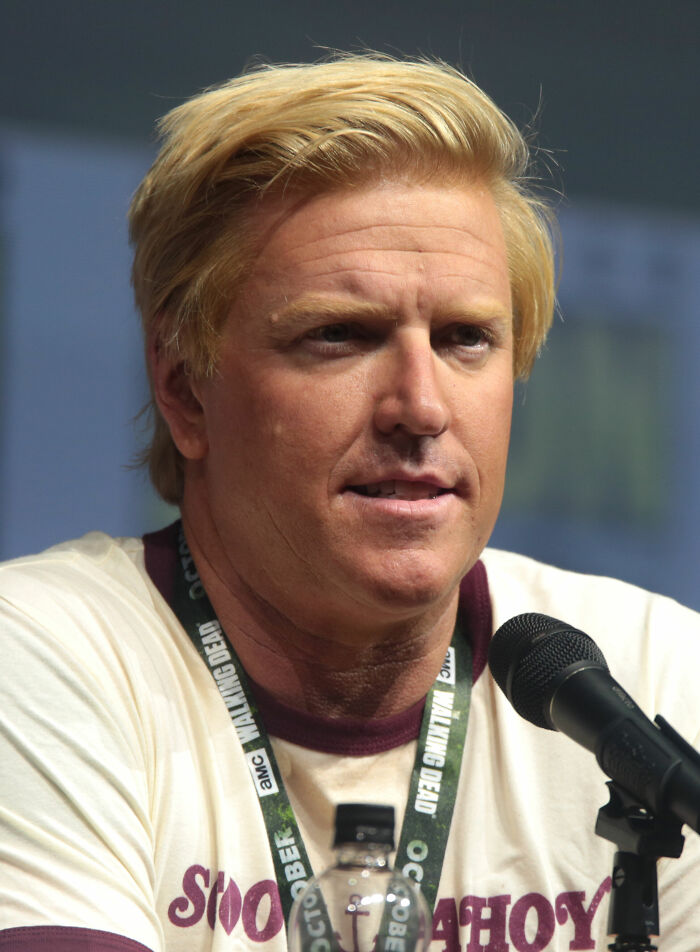 Close-up of Jake Busey speaking into a microphone at a panel event