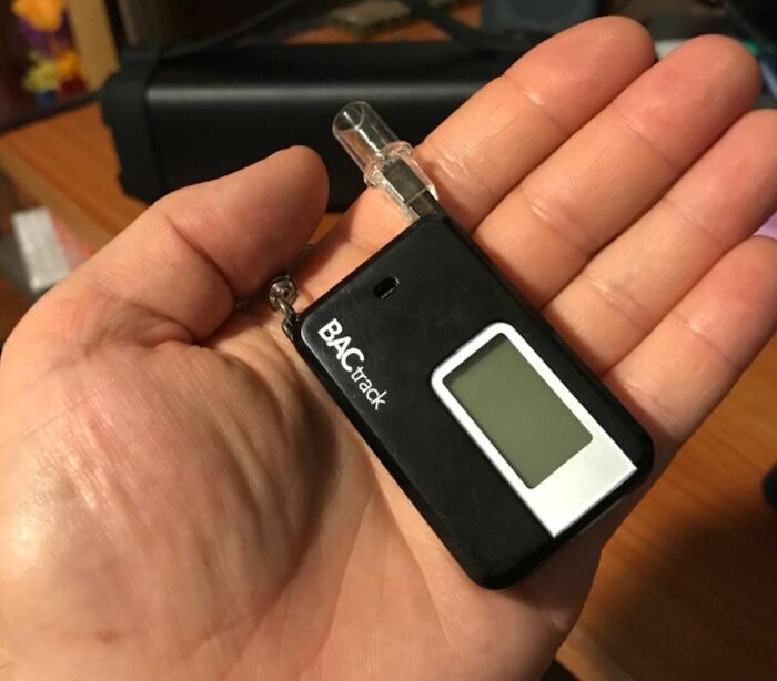 Hand holding BACtrack breathalyzer device for funny Father's Day gifts