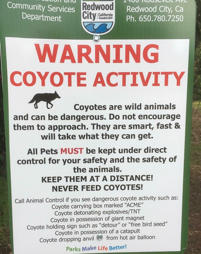 A warning sign about funny coyote activity, detailing strange behaviors like carrying an ACME box, found in the wild.