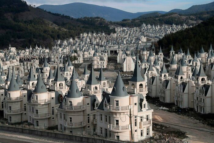 A sprawling, deeply unsettling liminal space featuring an abandoned village of identical, castle-like houses.