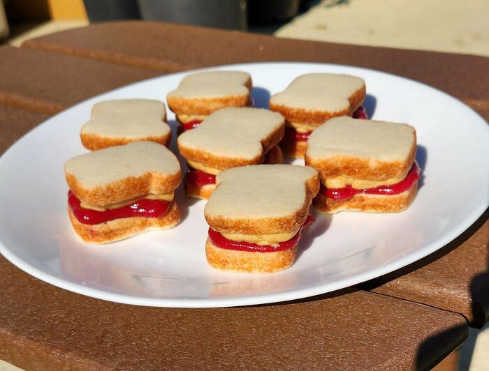 Mini peanut butter and jelly sandwich cookies on a white plate, amazing and delicious treats by bakers.