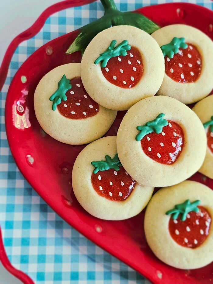 Strawberry cookies on a red plate, showcasing amazing and delicious treats made by talented bakers.
