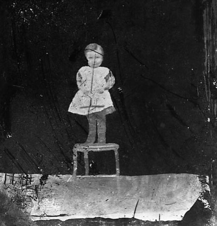 A Child Standing On A Chair