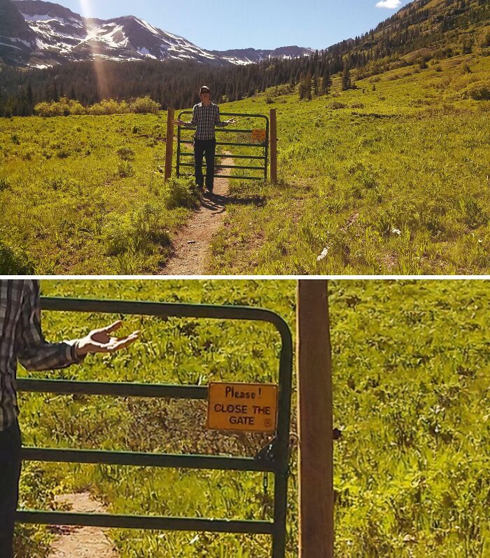A person stands by an open gate with a funny sign that says Please! Close the Gate in a grassy field.