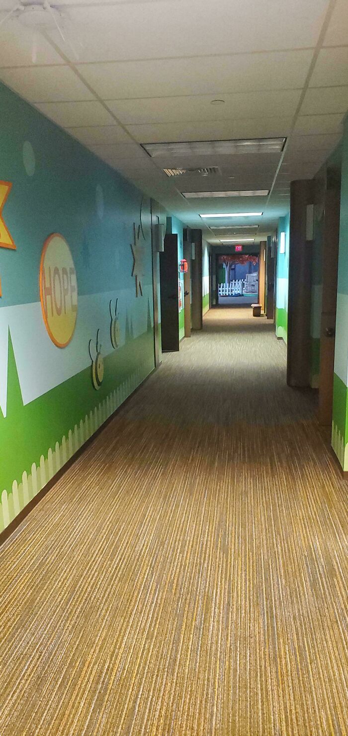 Long, painted hallway with the word HOPE on the wall, an unsettling liminal space.