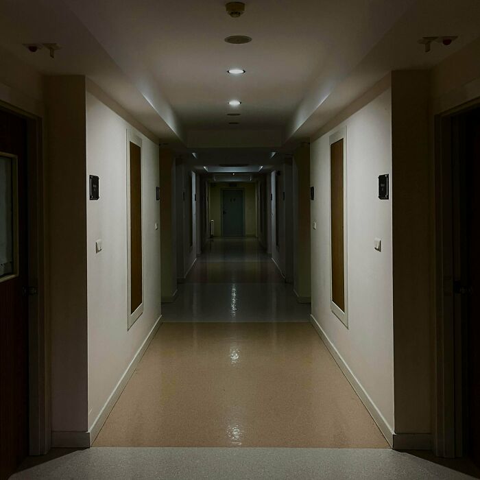 A long, dimly lit hallway in an unsettling building, depicting a classic liminal space.
