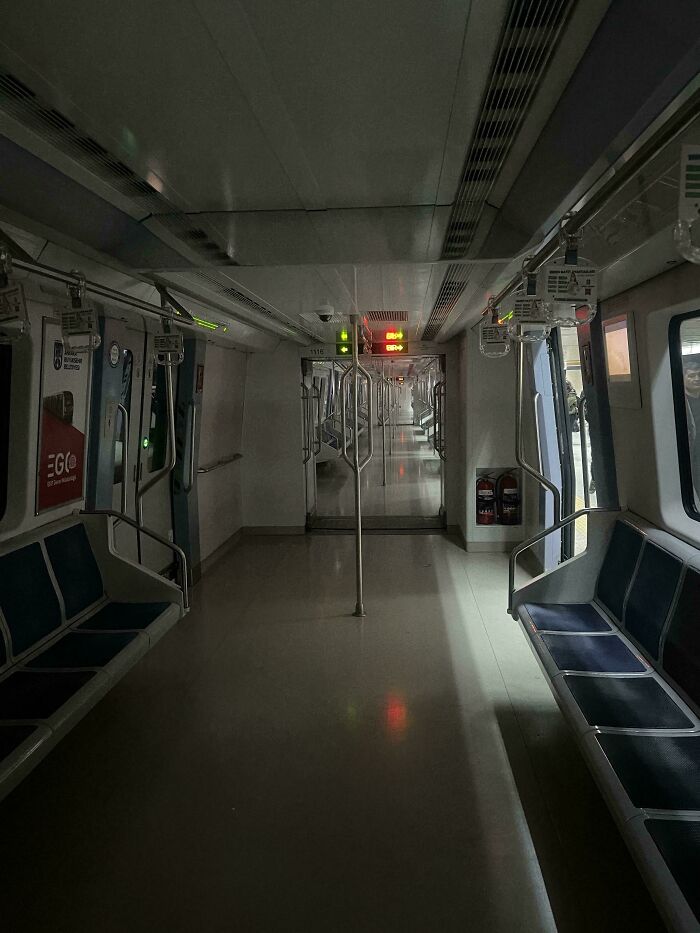 An empty subway car interior with blue seats and dim lighting, creating an unsettling liminal space.