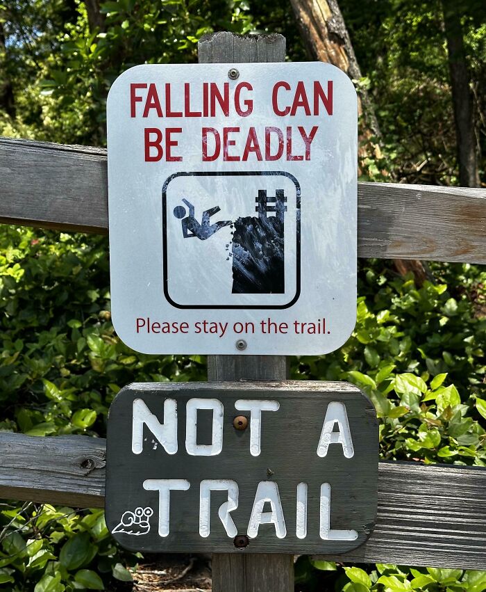 A funny sign warning about falling and a second sign saying Not A Trail, found in the wild.