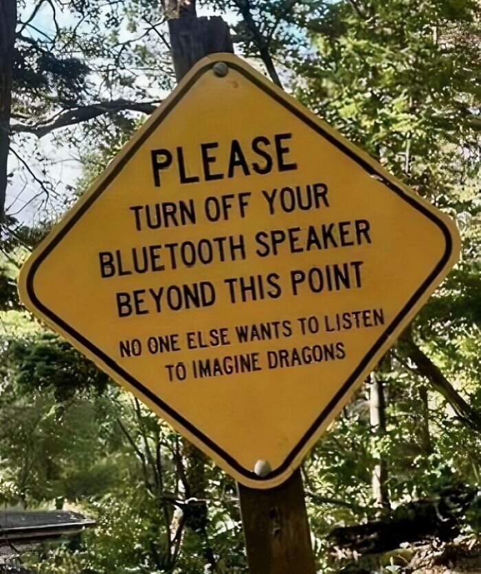 A yellow diamond-shaped funny sign asking people to turn off Bluetooth speakers beyond this point, found in the wild.