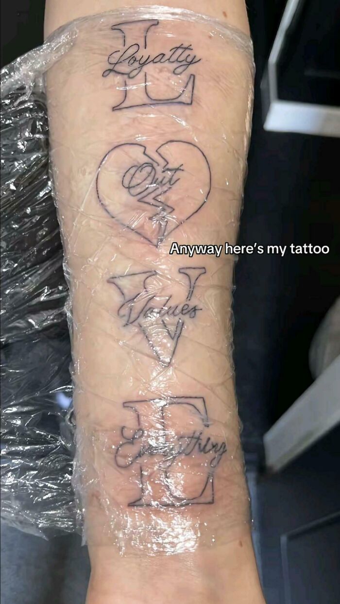 arm tattoo spelling loyalty with spelling errors and broken heart