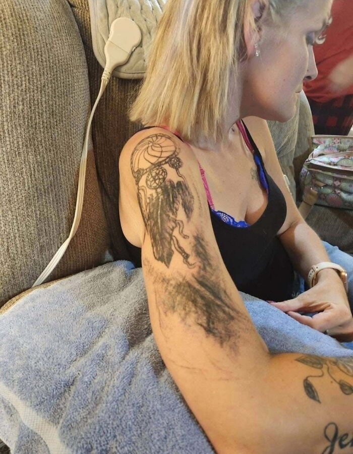 Ink smudge tattoo fail of dreamcatcher on woman's upper arm