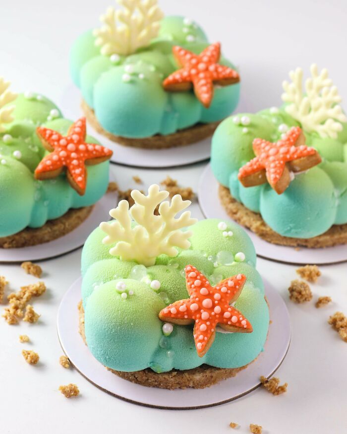 Four individual oceanic treats with starfish and coral decorations, showcasing amazing and delicious baking.
