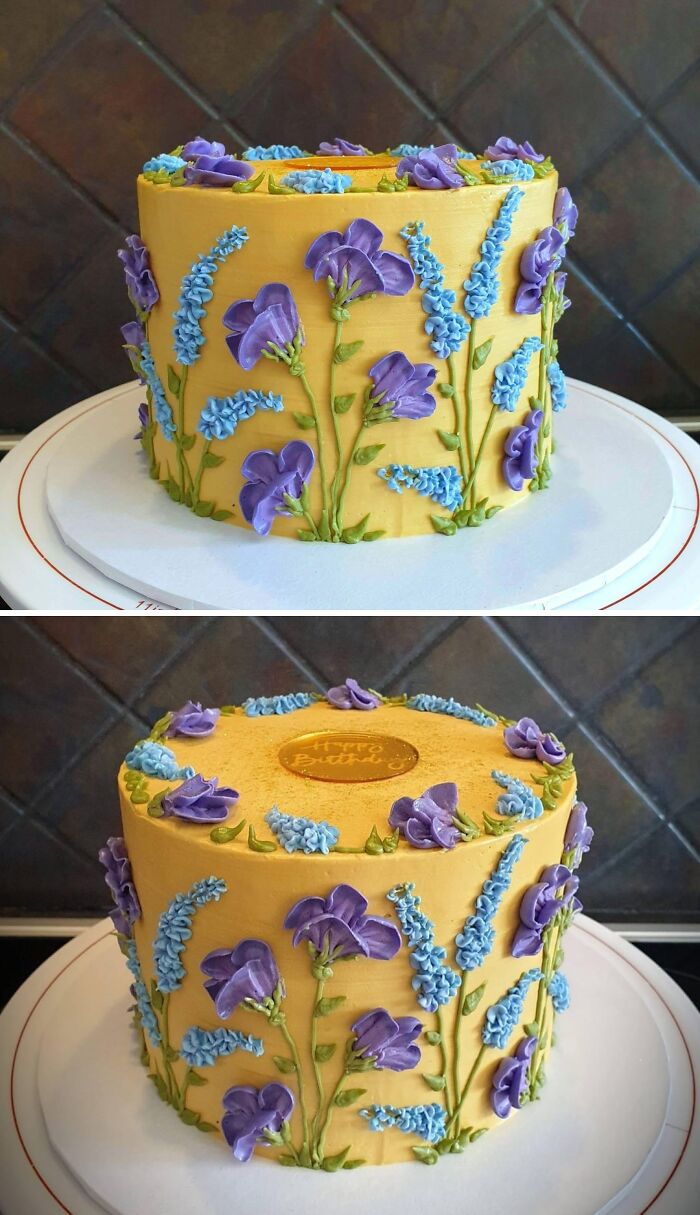 Yellow cake with intricate purple and blue flower buttercream decorations