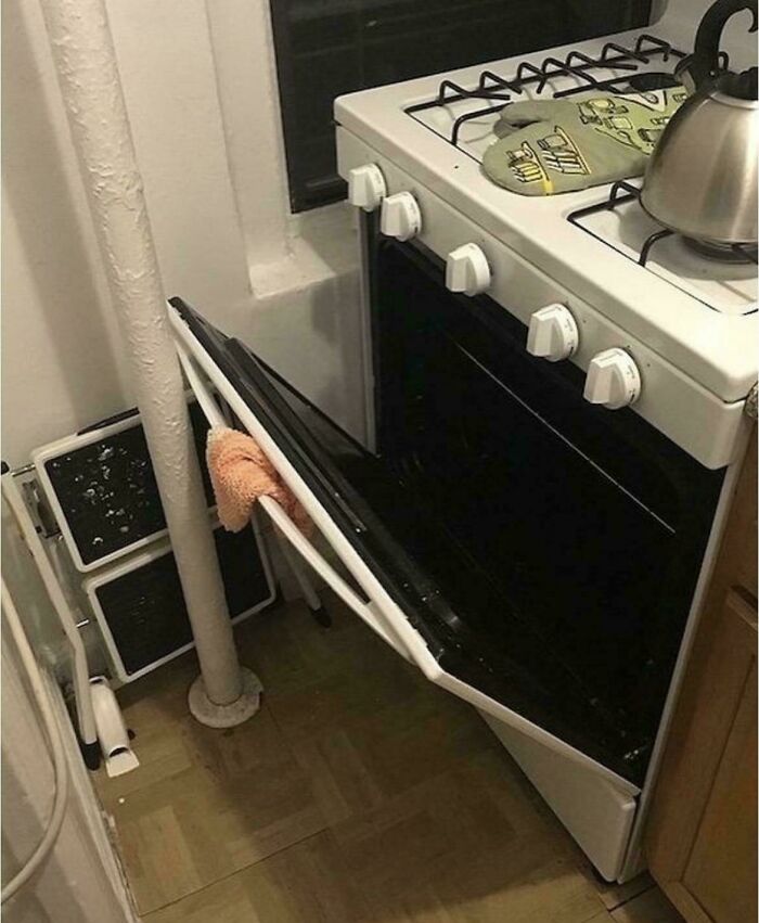 An unhinged real estate listing featuring a broken oven, with its door propped open by a cloth.