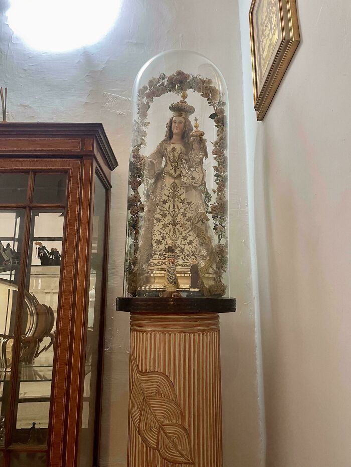 An ornate religious statue under a glass dome, included in unhinged real estate listings.