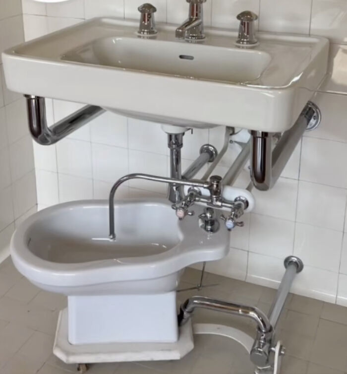 An unhinged real estate listing featuring an unusual bathroom setup with a sink directly above a bidet.
