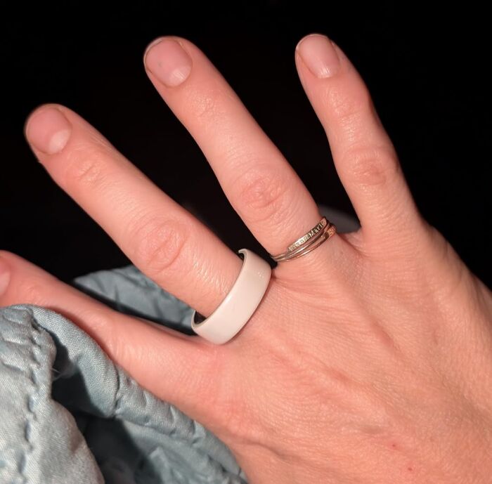Hand wearing a white silicone ring and silver bands, showcasing a fantastic Prime Day Deal.