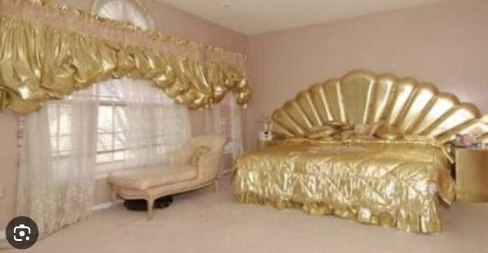 A gaudy bedroom with gold bedding, headboard, and window treatments, an example of unhinged real estate listings.